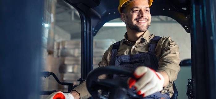 A man in a hat operating a forklift machine in a warehouse in Toledo, OH