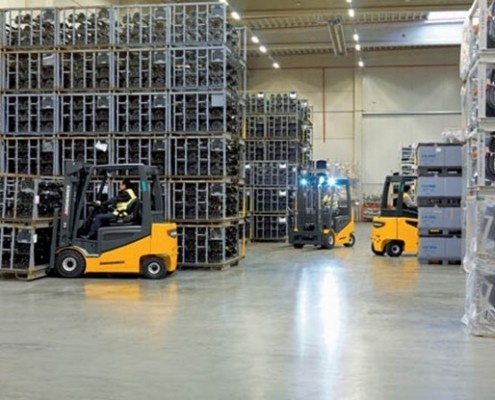 multiple-forklifts Warehouse supervisor checking information on a tablet